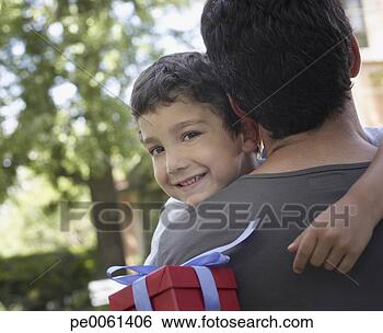 Banco de Imagem - abraçando,   sorrindo, 
  jovem,   menino, 
  segurando,  
 presente. fotosearch 
- busca de fotos, 
imagens e clipart