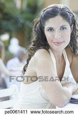 Arquivo de Fotografia - mulher,  ao ar 
livre,  partido, 
 sentando,  tabela, 
 sorrindo. fotosearch 
- busca de fotos, 
imagens e clipart