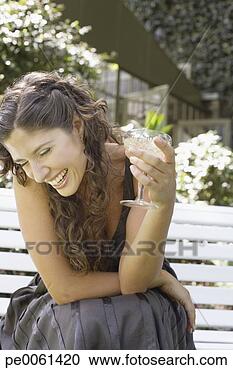 Arquivo de Fotografias - mulher,  ao ar 
livre,  sentando, 
 banco,  branca, 
 vinho,  rir. 
fotosearch - busca 
de fotos, imagens 
e clipart