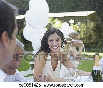 Banco de Imagem - mulher,   sentando, 
  tabela,   ao 
ar livre,   partido, 
  sorrindo. fotosearch 
- busca de fotos, 
imagens e clipart