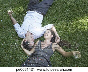 Arquivo de Fotografia - par,  ao ar livre, 
 mentindo,  capim, 
 branca,  vinho, 
 confetti,  rir. 
fotosearch - busca 
de fotos, imagens 
e clipart