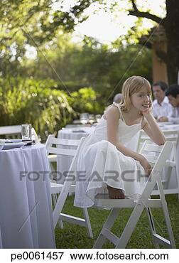 Picture - young girl crouched 
on chair at outdoor 
party smiling. 
fotosearch - search 
stock photos, 
pictures, images, 
and photo clipart