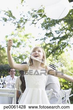 Stock Photo - young girl at 
outdoor party 
holding balloons 
smiling with people 
in. fotosearch 
- search stock 
photos, pictures, 
images, and photo 
clipart