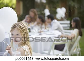 Stock Photo - young girl sitting 
at outdoor party 
with balloons 
smiling. fotosearch 
- search stock 
photos, pictures, 
images, and photo 
clipart
