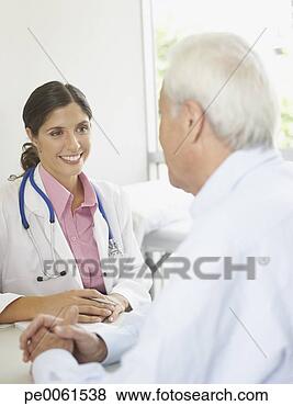 Stock Photo - doctor and patient 
sitting in office 
talking and smiling. 
fotosearch - search 
stock photos, 
pictures, images, 
and photo clipart