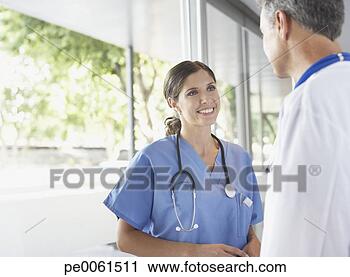 Arquivo de Fotografia - dois,  hospitalar, 
 trabalhadores, 
 corredor,  falando, 
 sorrindo. fotosearch 
- busca de fotos, 
imagens e clipart