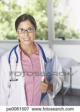 Foto - doutor,   ficar, 
  hospitalar, 
  segurando,  
 área de transferência. 
fotosearch - busca 
de fotos, imagens 
e clipart