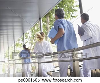 Stock Image - four hospital 
workers running 
down corridor. 
fotosearch - search 
stock photos, 
pictures, images, 
and photo clipart