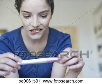 Picture - woman holding 
home pregnancy 
test and looking 
worried. fotosearch 
- search stock 
photos, pictures, 
images, and photo 
clipart