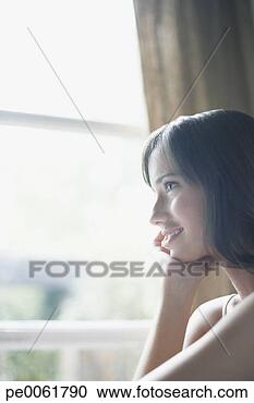 Arquivo de Fotografias - mulher,  olhar, 
 saída,  janela, 
 sorrindo. fotosearch 
- busca de fotos, 
imagens e clipart