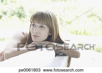 Stock Photo - woman sitting 
outdoors on patio 
lounger thinking. 
fotosearch - search 
stock photos, 
pictures, images, 
and photo clipart