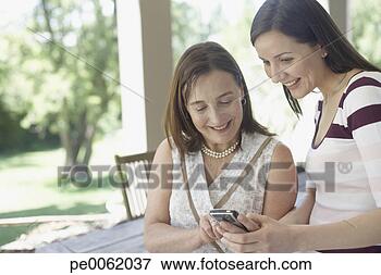 Foto - dois,  mulheres, 
 ao ar livre, 
 pátio,  usando, 
 pessoal,  digital. 
fotosearch - busca 
de fotos, imagens 
e clipart