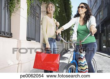 Banco de Imagem - dois,   mulheres, 
  ao ar livre, 
  bicicleta,  
 shopping,   sacolas. 
fotosearch - busca 
de fotos, imagens 
e clipart