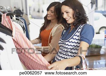 Foto - dois,  mulheres, 
 loja,  olhar, 
 vestidos,  sorrindo. 
fotosearch - busca 
de fotos, imagens 
e clipart