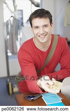 Stock Photo - man at cashier 
in store paying 
with credit card 
and smiling. fotosearch 
- search stock 
photos, pictures, 
images, and photo 
clipart