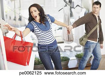 Stock Image - man in store trying 
to pull woman 
away from clothes 
rack. fotosearch 
- search stock 
photos, pictures, 
images, and photo 
clipart