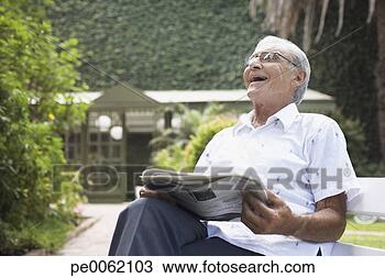 Stock Photo - senior man sitting 
outdoors with 
newspaper laughing. 
fotosearch - search 
stock photos, 
pictures, images, 
and photo clipart
