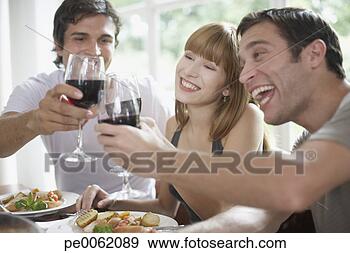 Stock Photograph - three people toasting 
red wine at dinner 
table and smiling. 
fotosearch - search 
stock photos, 
pictures, images, 
and photo clipart