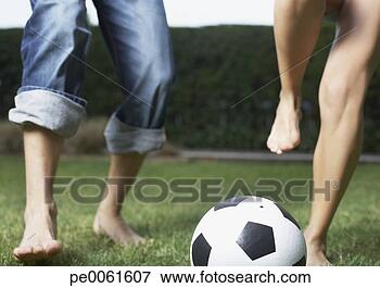 Foto - dois,  pessoas, 
 tocando,  futebol, 
 ao ar livre. 
fotosearch - busca 
de fotos, imagens 
e clipart