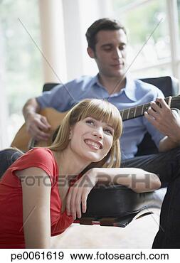 Stock Photograph - man playing acoustic 
guitar indoors 
with woman listening. 
fotosearch - search 
stock photos, 
pictures, images, 
and photo clipart