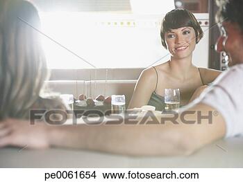 Stock Photo - three people at 
birthday party 
in restaurant 
talking and smiling. 
fotosearch - search 
stock photos, 
pictures, images, 
and photo clipart