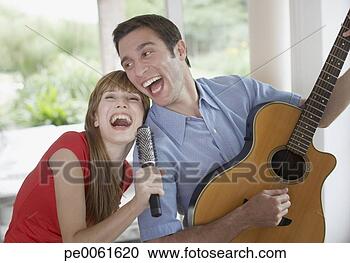 Arquivo de Fotografias - tocando,  acústico, 
 guitarra,  dentro, 
 mulher,  cantando, 
 hairbrush. fotosearch 
- busca de fotos, 
imagens e clipart