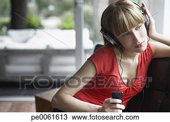 Stock Photo - woman sitting 
in living room 
listening to mp3 
player. fotosearch 
- search stock 
photos, pictures, 
images, and photo 
clipart