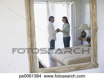 Stock Photo - mirror reflection 
of a couple in 
their bedroom 
holding hands 
and. fotosearch 
- search stock 
photos, pictures, 
images, and photo 
clipart