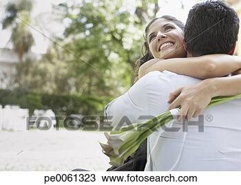 Banco de Imagem - par,  abraçar, 
 ao ar livre, 
 flores,  sorrindo. 
fotosearch - busca 
de fotos, imagens 
e clipart