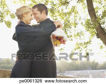 Banco de Imagem - par,  abraçar, 
 ao ar livre, 
 flores,  sorrindo. 
fotosearch - busca 
de fotos, imagens 
e clipart