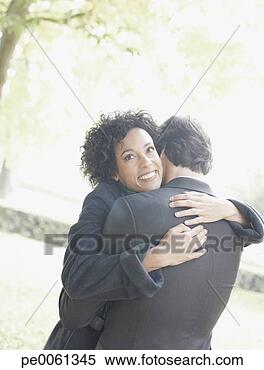 Banco de Imagem - par,  abraçar, 
 ao ar livre, 
 sorrindo. fotosearch 
- busca de fotos, 
imagens e clipart