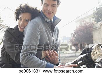 Foto - par,  ao ar livre, 
 elétrico,  scooter, 
 sorrindo. fotosearch 
- busca de fotos, 
imagens e clipart