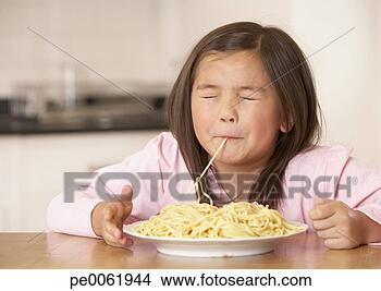 Banco de Imagem - jovem,  menina, 
 cozinha,  comer, 
 espaguete,  noodles. 
fotosearch - busca 
de fotos, imagens 
e clipart