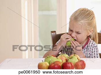 Arquivo de Fotografias - jovem,  menina, 
 cozinha,  comer, 
 maçã. fotosearch 
- busca de fotos, 
imagens e clipart