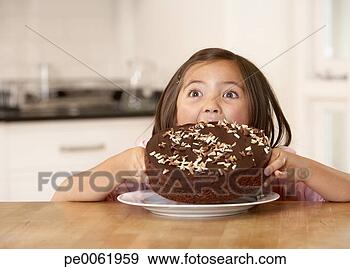 Stock Photograph - young girl in 
kitchen trying 
to eat an entire 
cake all at once. 
fotosearch - search 
stock photos, 
pictures, images, 
and photo clipart