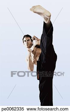Stock Image - man practicing 
martial arts and 
kicking. fotosearch 
- search stock 
photos, pictures, 
images, and photo 
clipart