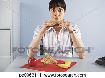 Stock Photography - businesswoman 
eating healthy 
lunch at desk. 
fotosearch - search 
stock photos, 
pictures, images, 
and photo clipart
