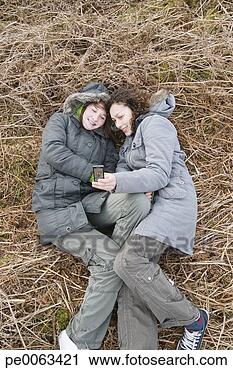 Stock Photography - teenage girls 
laying ground 
taking self-portrait. 
fotosearch - search 
stock photos, 
pictures, images, 
and photo clipart