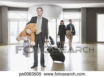 Stock Image - businessman in 
lobby with suitcase 
and stuffed animal. 
fotosearch - search 
stock photos, 
pictures, images, 
and photo clipart