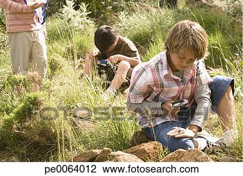 Stock Photo - children looking 
at insects through 
magnifying glass. 
fotosearch - search 
stock photos, 
pictures, images, 
and photo clipart