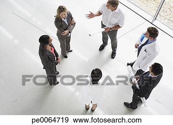 Stock Photograph - businesspeople 
standing having 
a meeting. fotosearch 
- search stock 
photos, pictures, 
images, and photo 
clipart