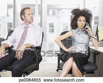 Stock Image - businessman looking 
at co-worker talking 
on telephone. 
fotosearch - search 
stock photos, 
pictures, images, 
and photo clipart