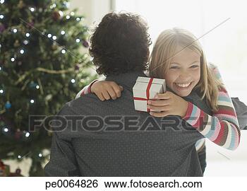 Stock Photo - daughter hugging 
father holding 
christmas gift. 
fotosearch - search 
stock photos, 
pictures, images, 
and photo clipart