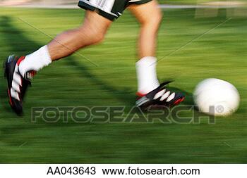 Stock Photo - young man kicking 
soccer ball. fotosearch 
- search stock 
photos, pictures, 
images, and photo 
clipart