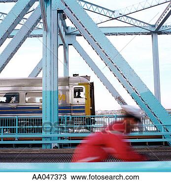 Stock Photo - fast moving cyclist 
and train crossing 
bridge. fotosearch 
- search stock 
photos, pictures, 
images, and photo 
clipart