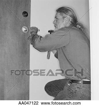 Stock Photo - locksmith installing 
lock. fotosearch 
- search stock 
photos, pictures, 
images, and photo 
clipart
