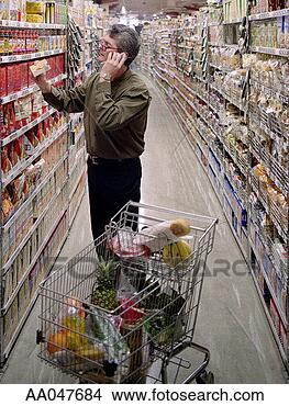 Stock Photo - man grocery shopping 
while on mobile 
phone. fotosearch 
- search stock 
photos, pictures, 
images, and photo 
clipart