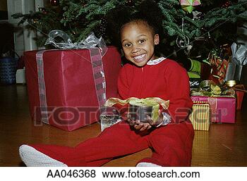 Stock Photo - portrait of a 
girl holding a 
present under 
the christmas 
tree. fotosearch 
- search stock 
photos, pictures, 
images, and photo 
clipart