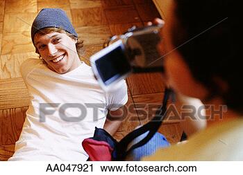 Stock Photography - young woman filming 
young man with 
digital camcorder. 
fotosearch - search 
stock photos, 
pictures, images, 
and photo clipart