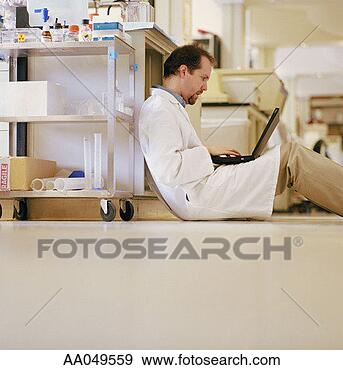 Stock Photograph - lab technician 
sitting on the 
floor with laptop. 
fotosearch - search 
stock photos, 
pictures, images, 
and photo clipart